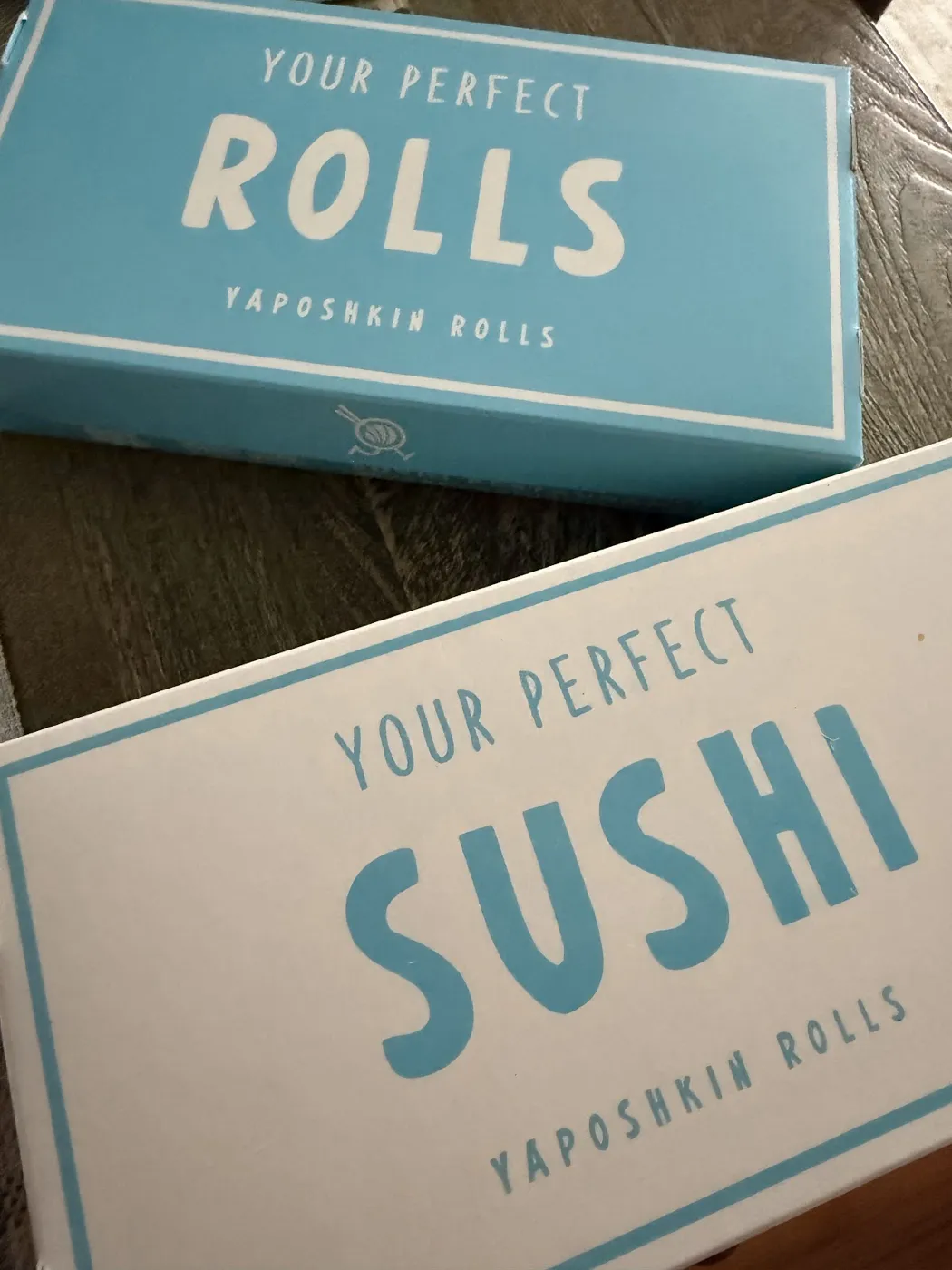 Yaposhkin Sushi boxes printed with the words your perfect rolls and your perfect sushi.